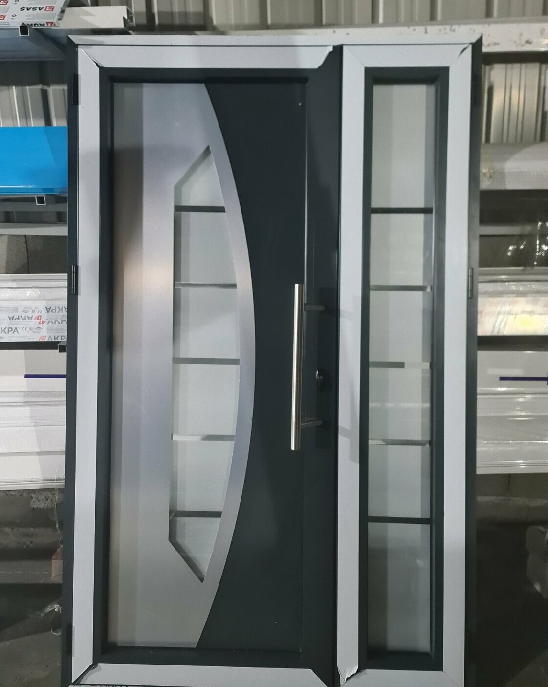Moderna ALU ulazna vrata sa bočnim staklenim panelom u fazi izrade u radionici, kombinacija antracit i bele boje sa dekorativnim staklom